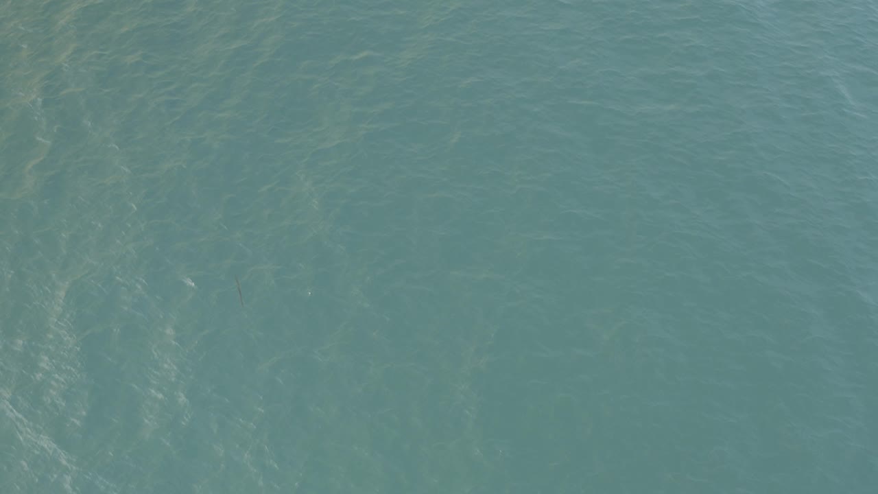 Blue-green sea surface in Baja California Sur, Mexico, with vertical shimmer patterns and no visible people.