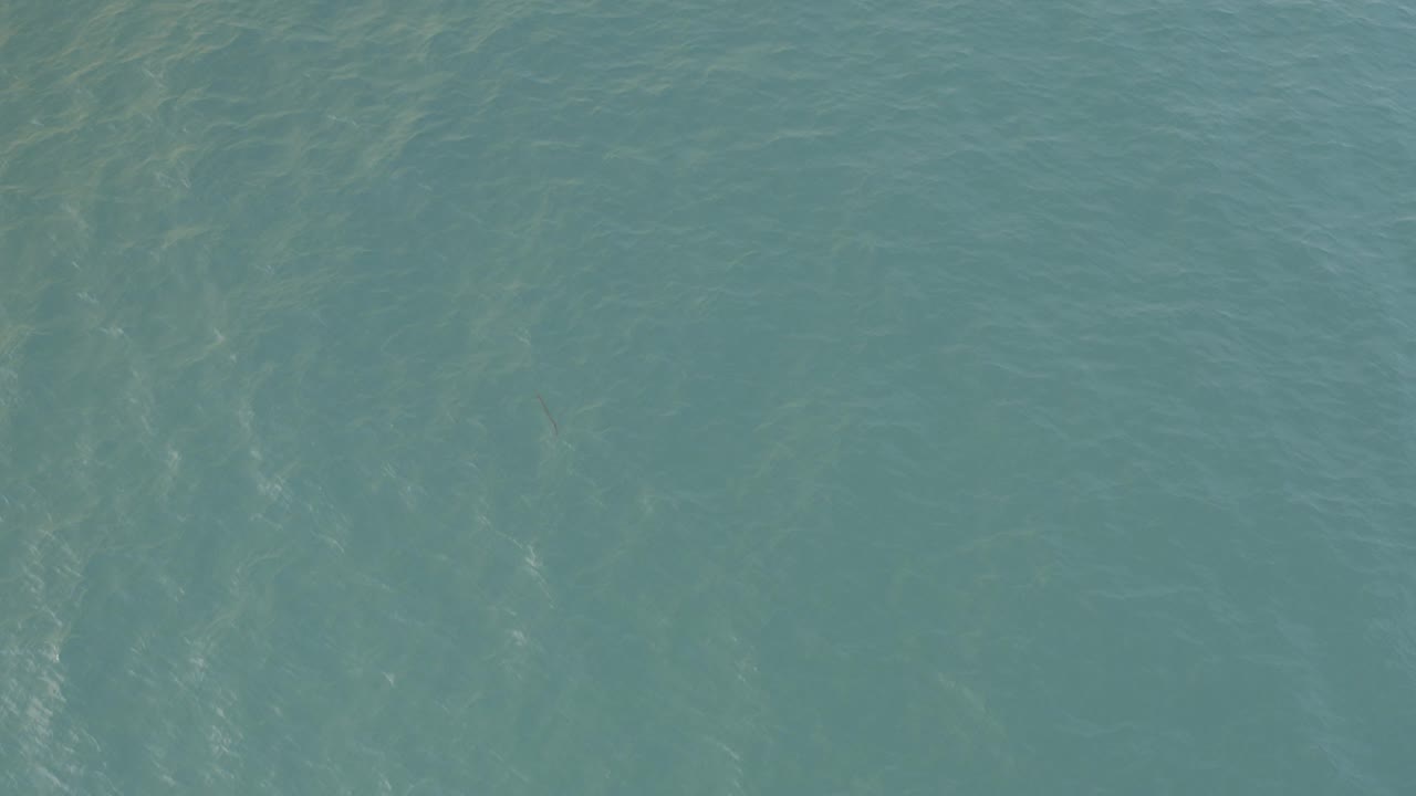 Overhead view of green-blue rippled water in Baja California Sur, Mexico, with soft light streaks across the surface and no visible people.