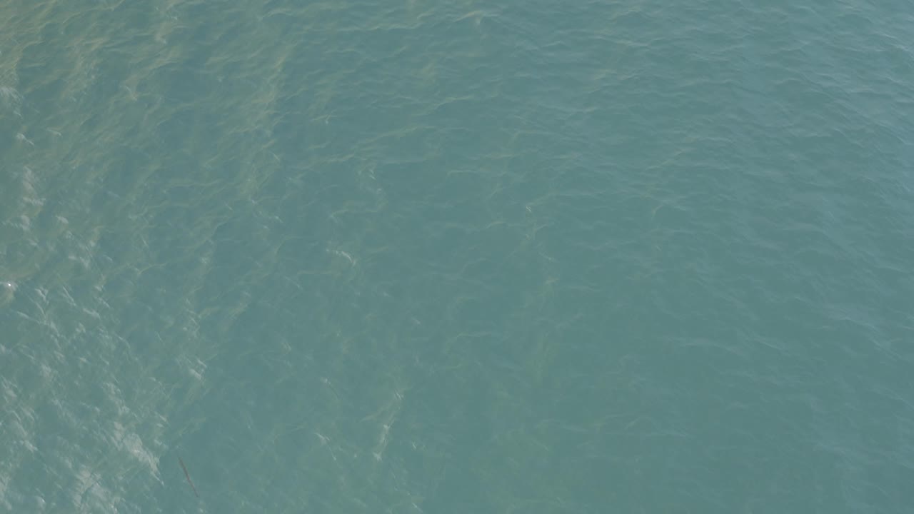 Top-down Baja California Sur water surface with a brighter vertical patch of reflected ripples and no visible people or vessels.