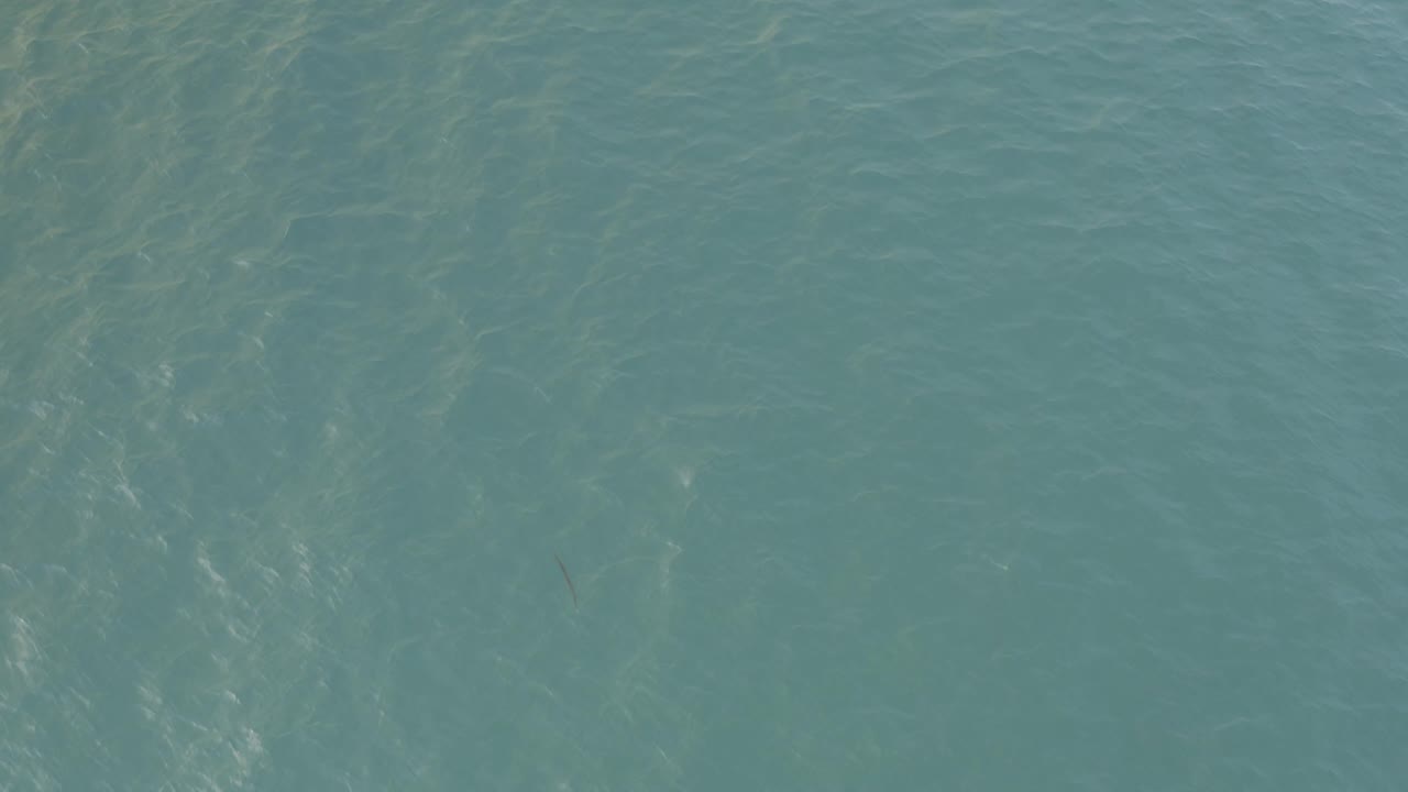 Turquoise water with faint wave streaks.
