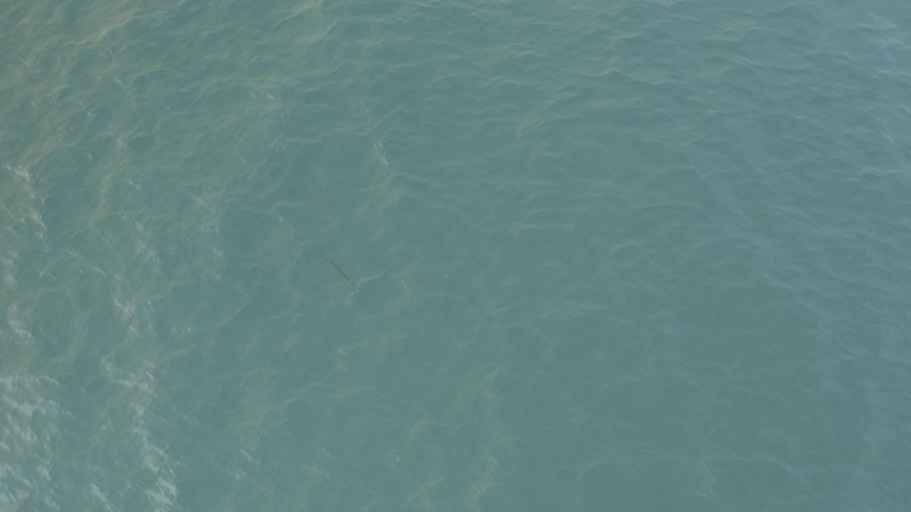 Close surface view of blue water in Baja California Sur, Mexico, with small wave patterns and a muted light shimmer, no visible people.