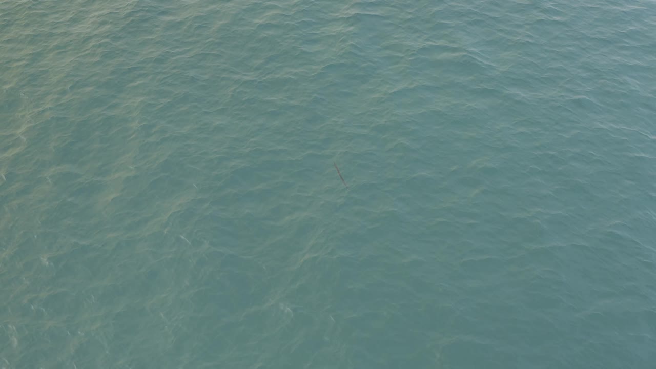 A downward view of Baja California Sur ocean water shows soft teal color, subtle current patterns, and no visible people or structures.