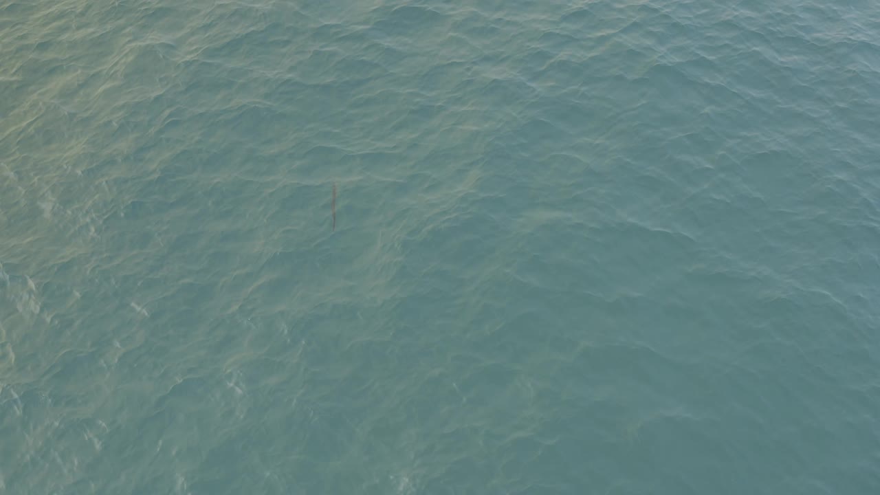 Overhead Baja California Sur ocean frame with pale submerged streaks crossing the turquoise water and no visible people.