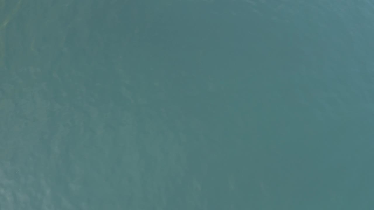 Open teal ocean in Baja California Sur, Mexico, with a darker surface patch near the top and fine ripples across the frame, no visible people.