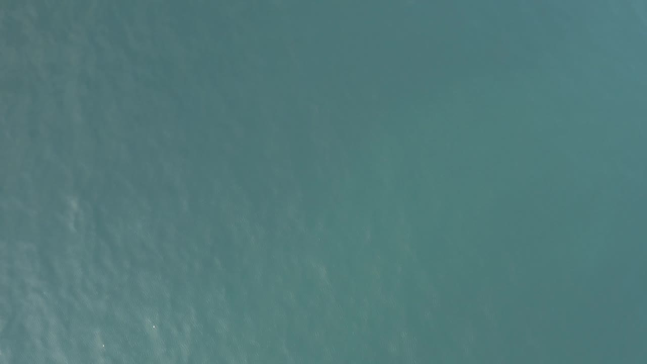 Aerial view over calm salt water in Baja California Sur, Mexico, with brighter ripple patterns near the upper frame and no visible people.