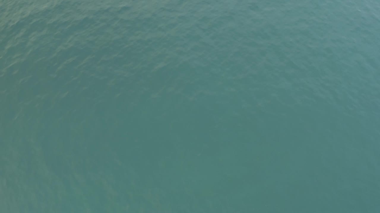 The Baja California Sur water appears slightly lighter in this frame, with pale streaks under the surface and no visible people or vessels.