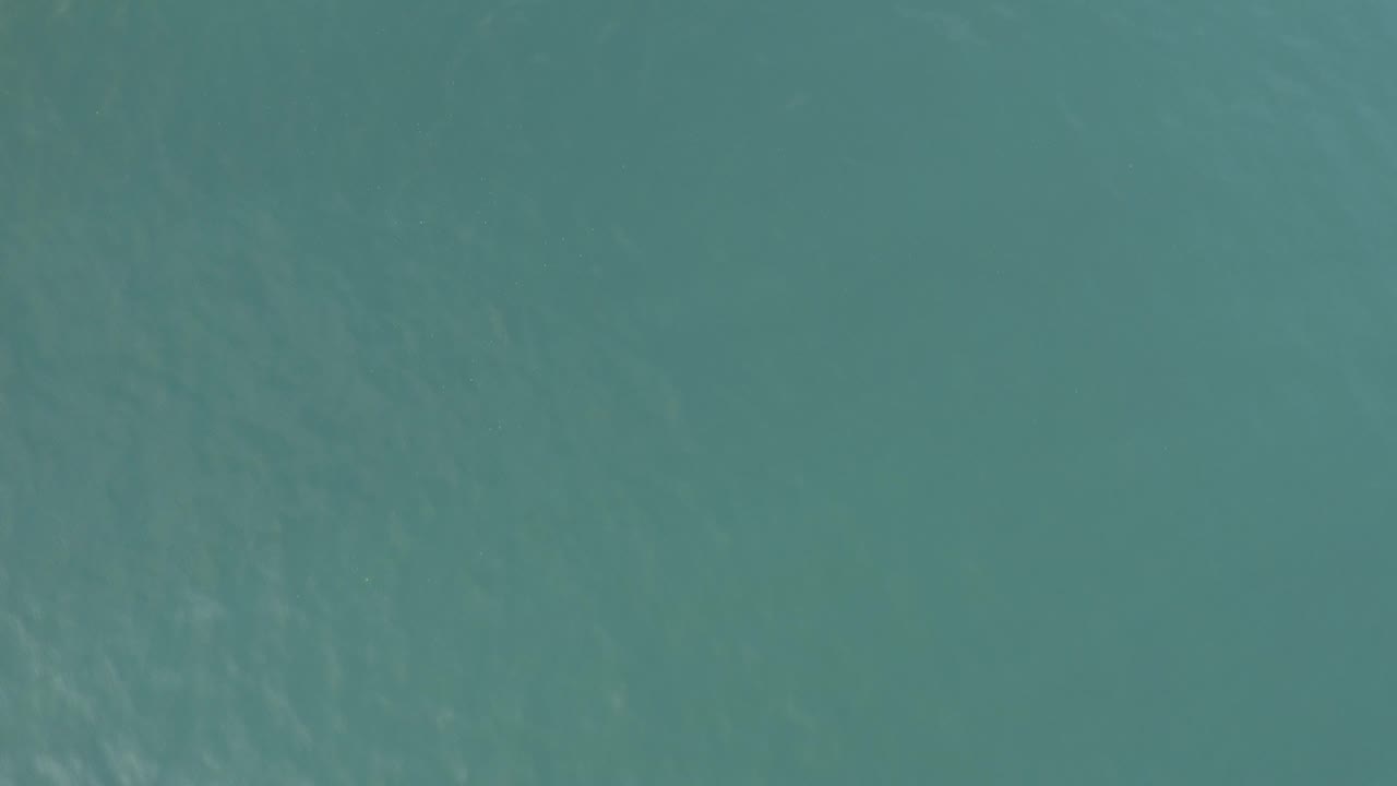 Top-down view of teal ocean water in Baja California Sur, Mexico, with faint ripples across the surface and no visible people.
