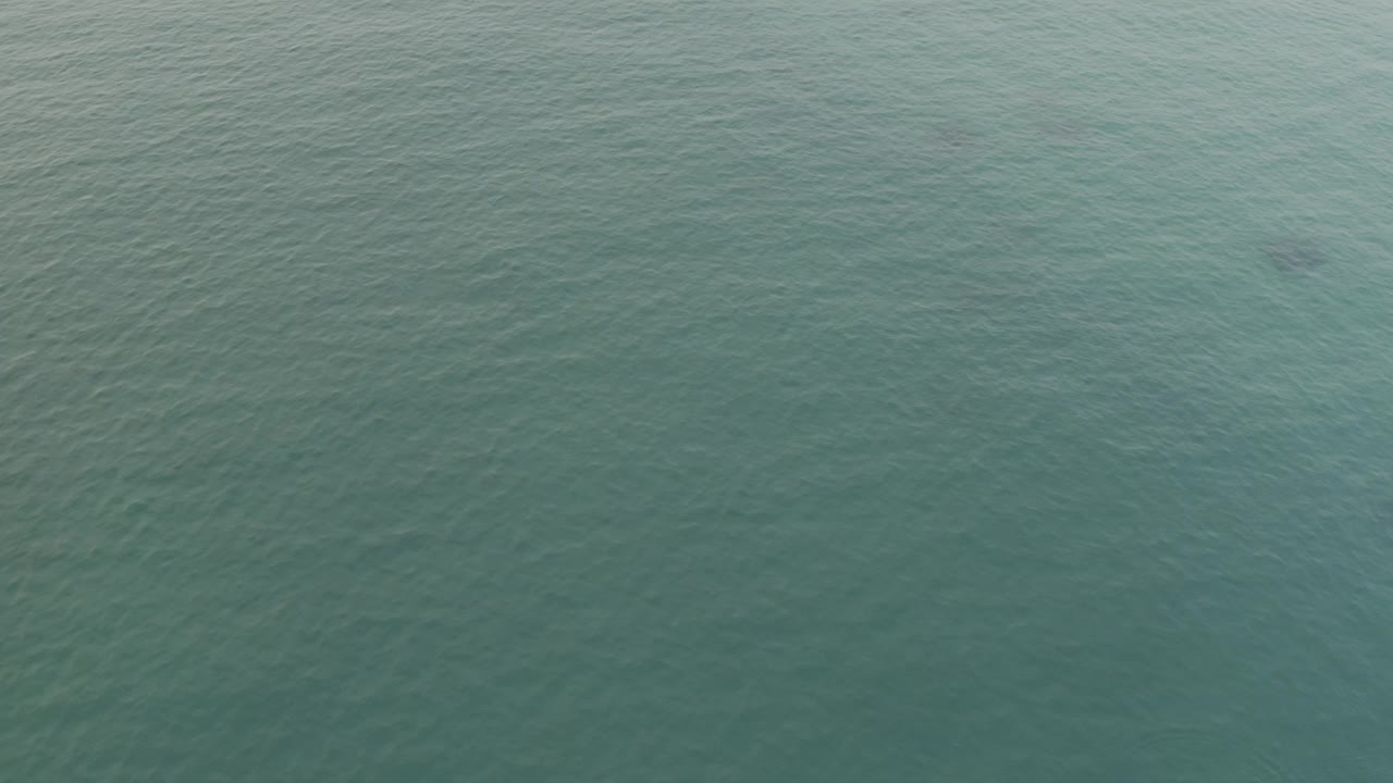 Aerial frame filled almost entirely by green-blue Baja California Sur ocean water, with faint ripples and no visible people.