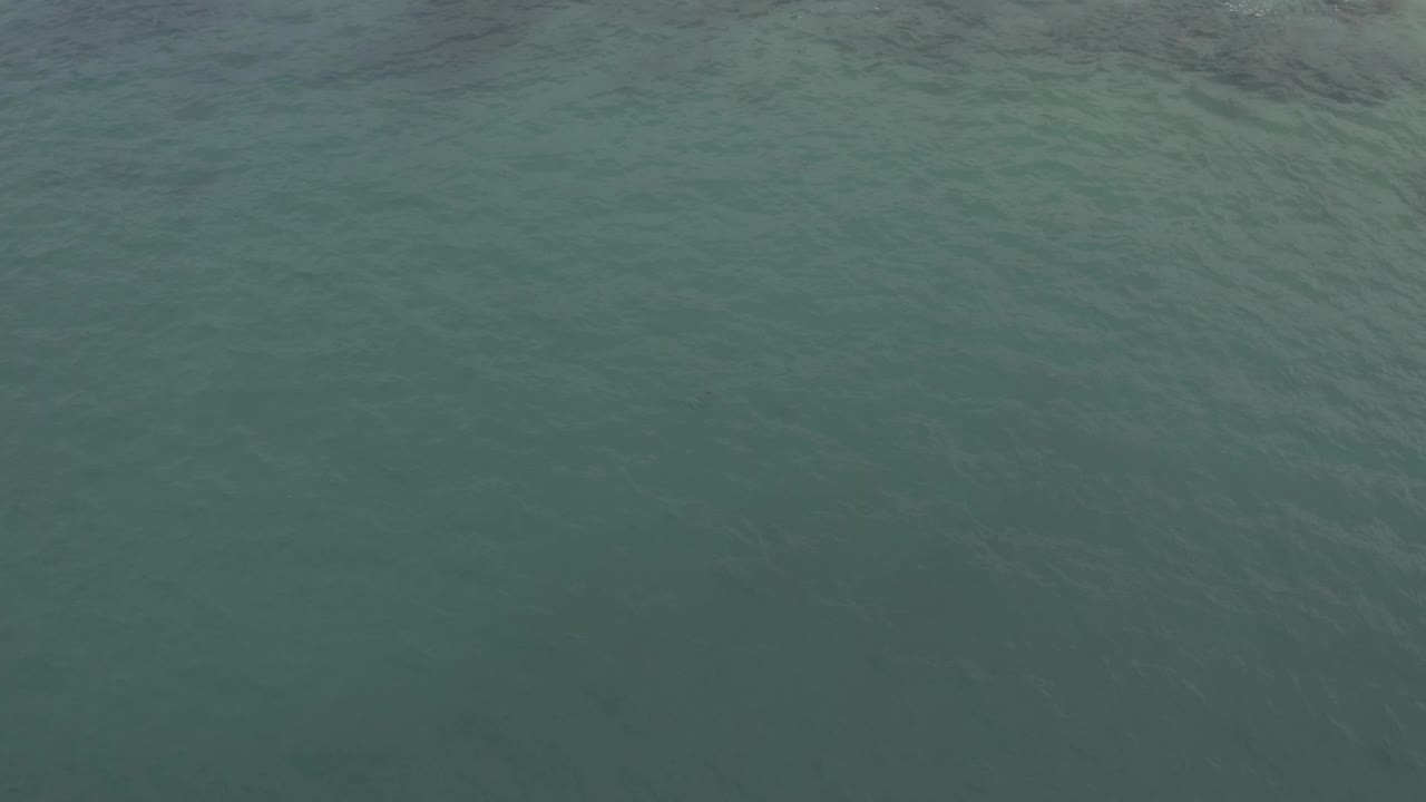 Calm teal water in Baja California Sur, Mexico shows faint wave lines across the full frame, with no visible people or structures.
