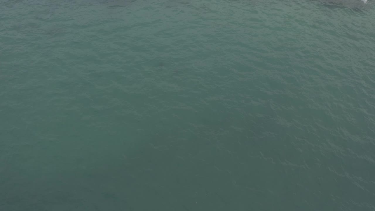 Overhead green ocean water in Baja California Sur, Mexico, with more visible ripples across the middle of the frame and no visible people.