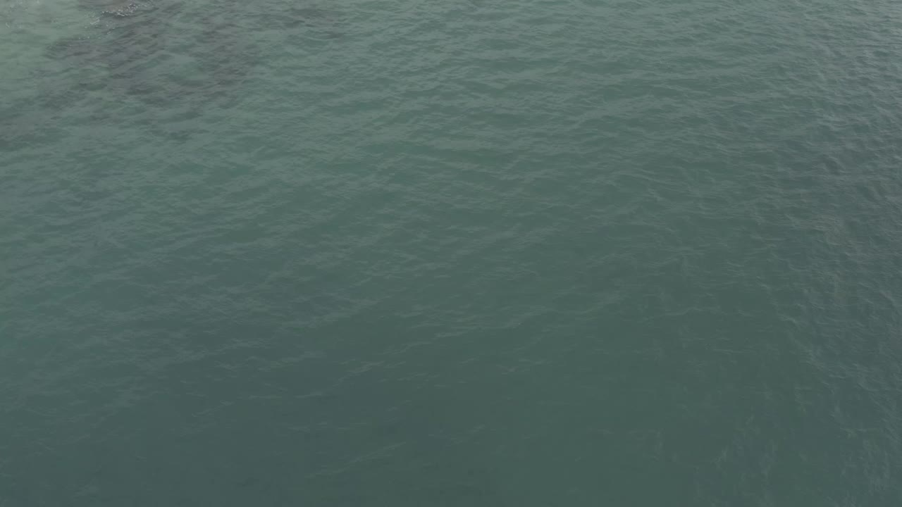 Shallow green-blue water with small white foam near the top