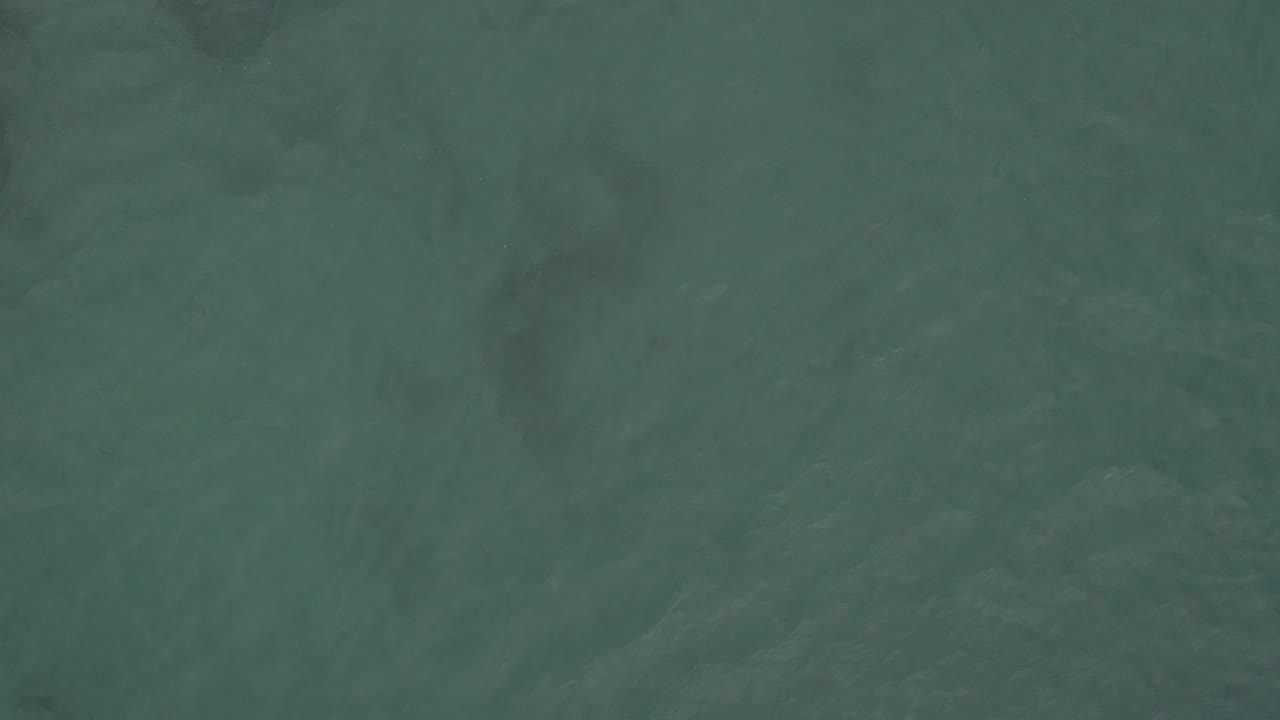 Green ocean water with darker cloudy patches