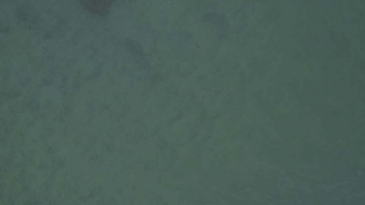 Aerial water view in Baja California Sur, Mexico, showing a darker blurred patch near the top of the frame and no visible people.