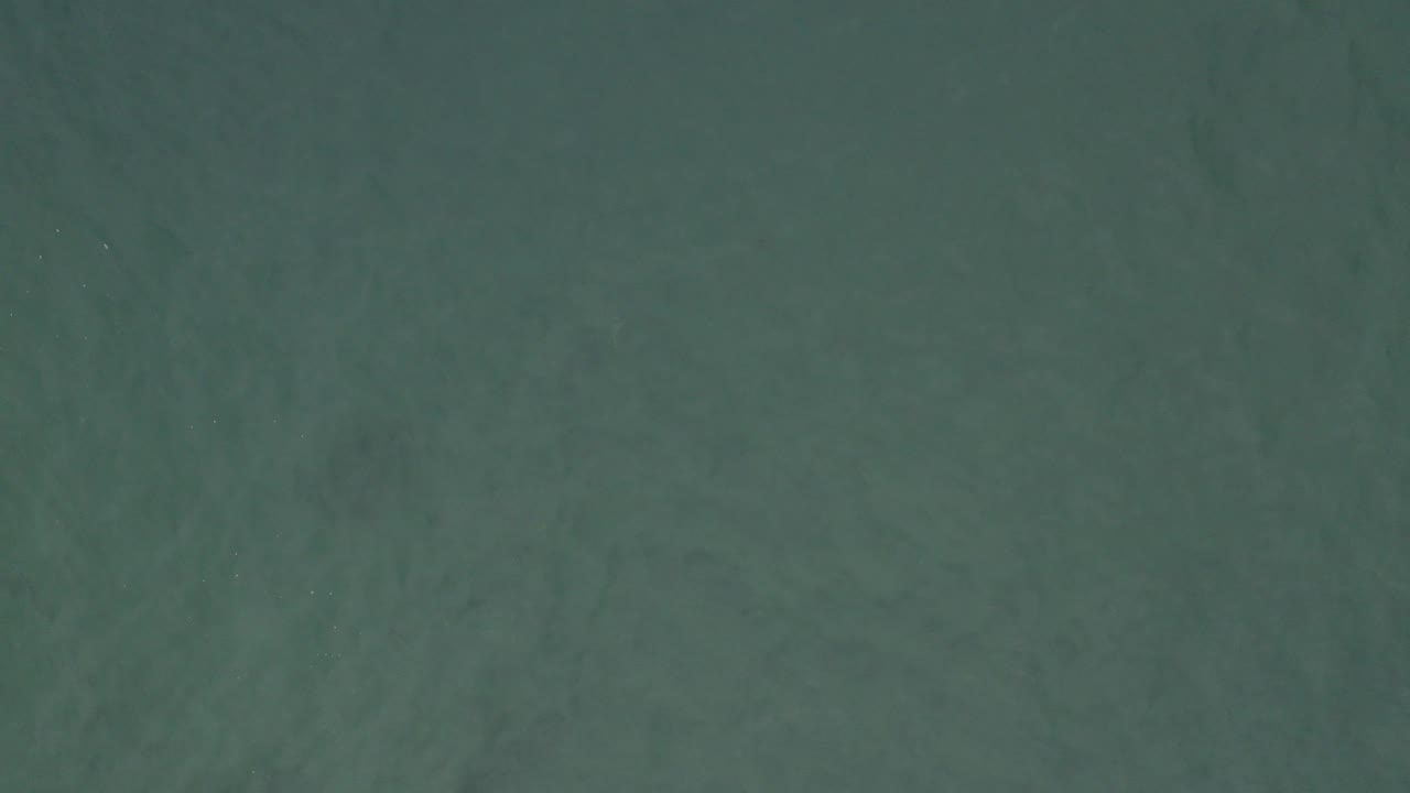 Overhead view of green-blue ocean water texture.