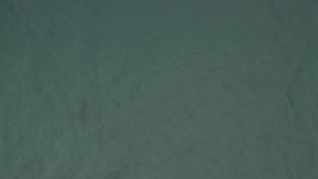 Aerial view of green-blue water in Baja California Sur, Mexico, showing darker underwater tones and no visible people.