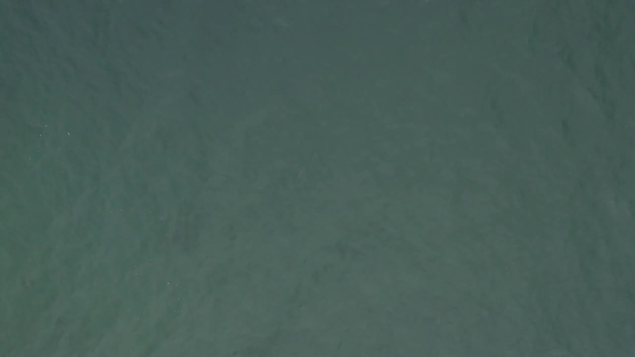 Overhead teal ocean surface in Baja California Sur, Mexico, with soft rippling texture and no visible people.