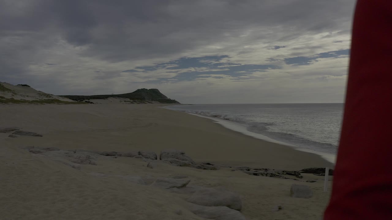 Beach and surf with a red sleeve along the right edge.