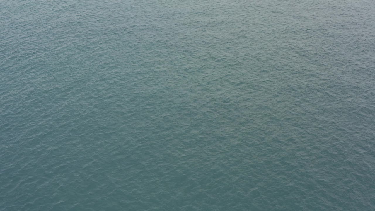 Blue-green ocean surface with fine ripples.