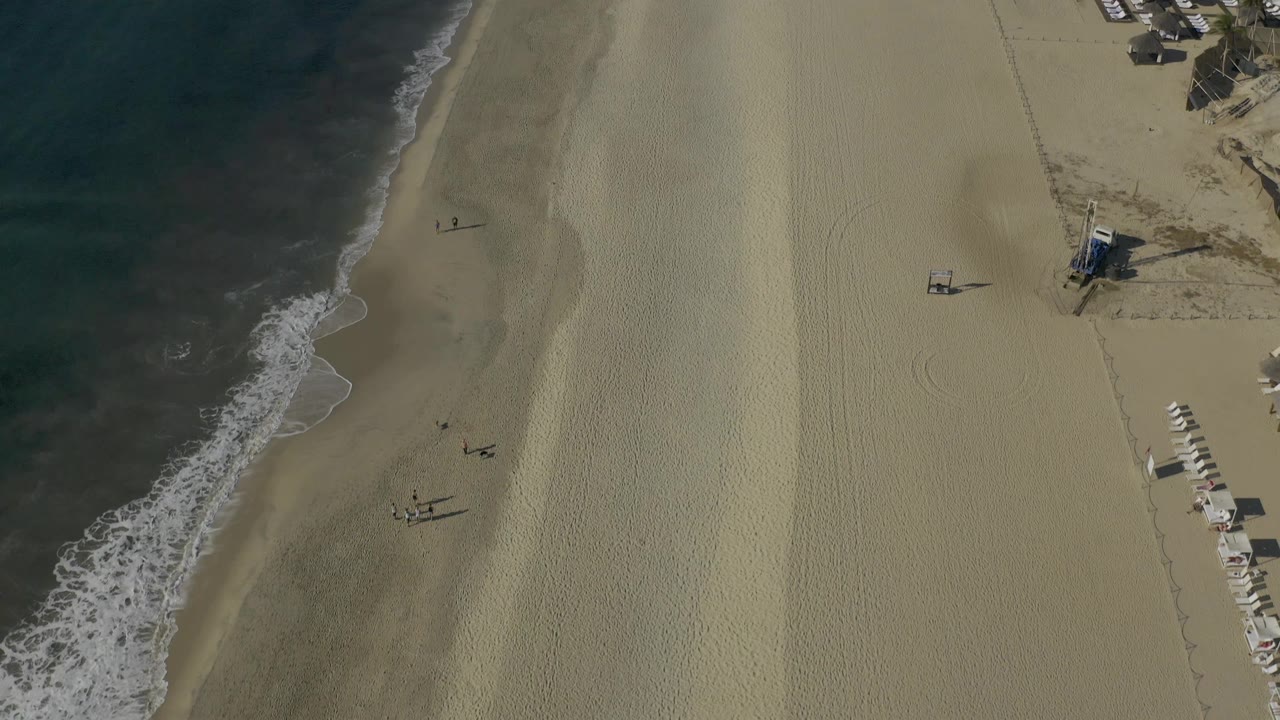 Drone view of shoreline and broad empty sand
