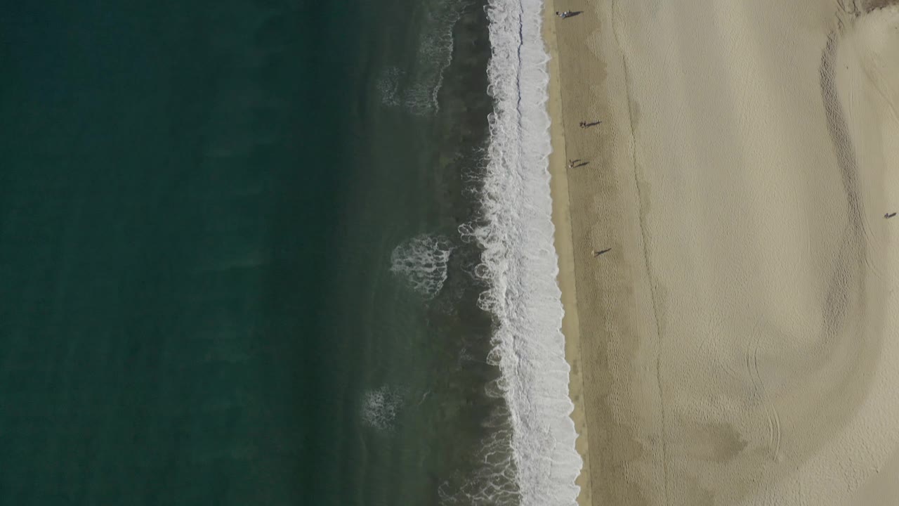 Aerial frame in Baja California Sur Mexico showing the surf line slightly farther along the beach, with open water left, sand right, and no visible people.