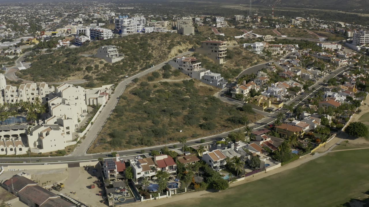 Drone view across dry hills and residential blocks
