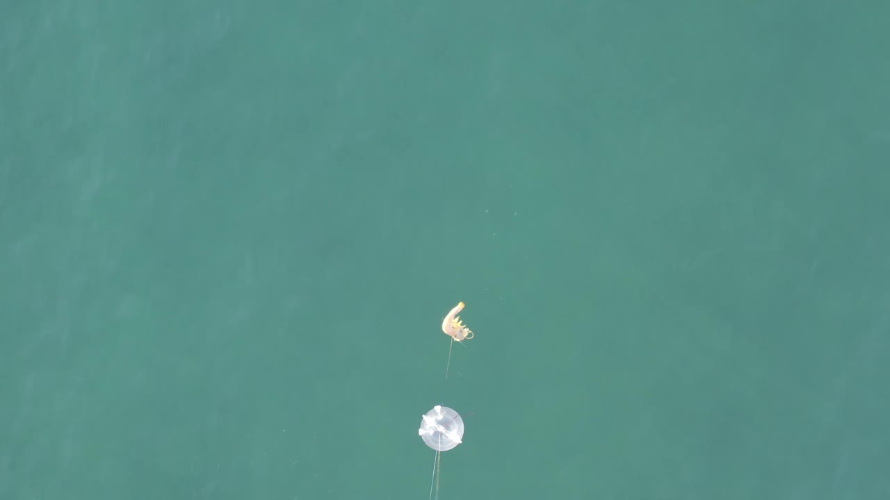 Fishing tackle suspended above open green-blue water