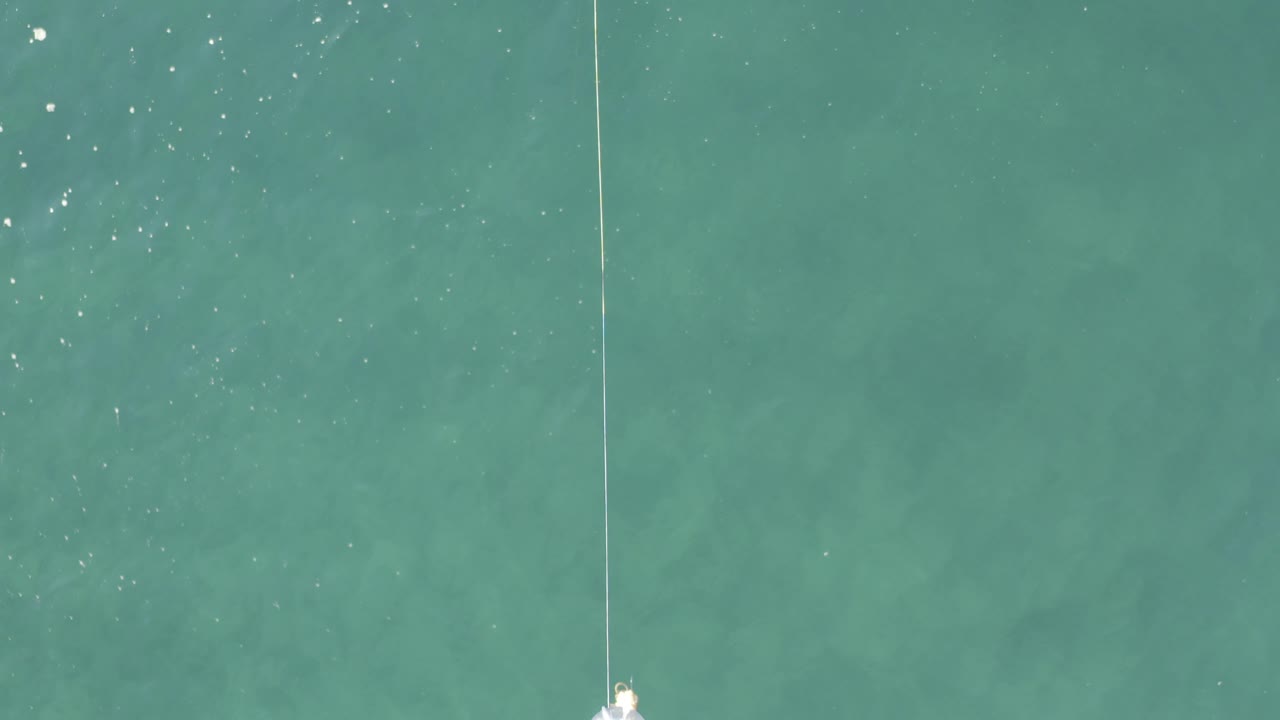 The lure appears close to the upper edge over clear Baja California Sur water, with a vertical line above it and no visible people in the frame.