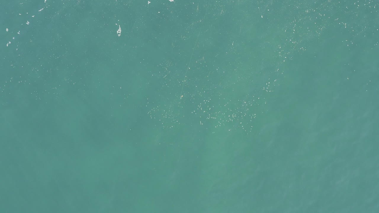 Overhead view of turquoise ocean water in Baja California Sur, Mexico, with scattered white wave flecks and no visible people.