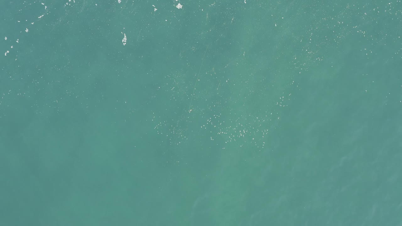 Blue-green ocean fills the frame in Baja California Sur, Mexico, with scattered bright specks from wave tops and no visible people.