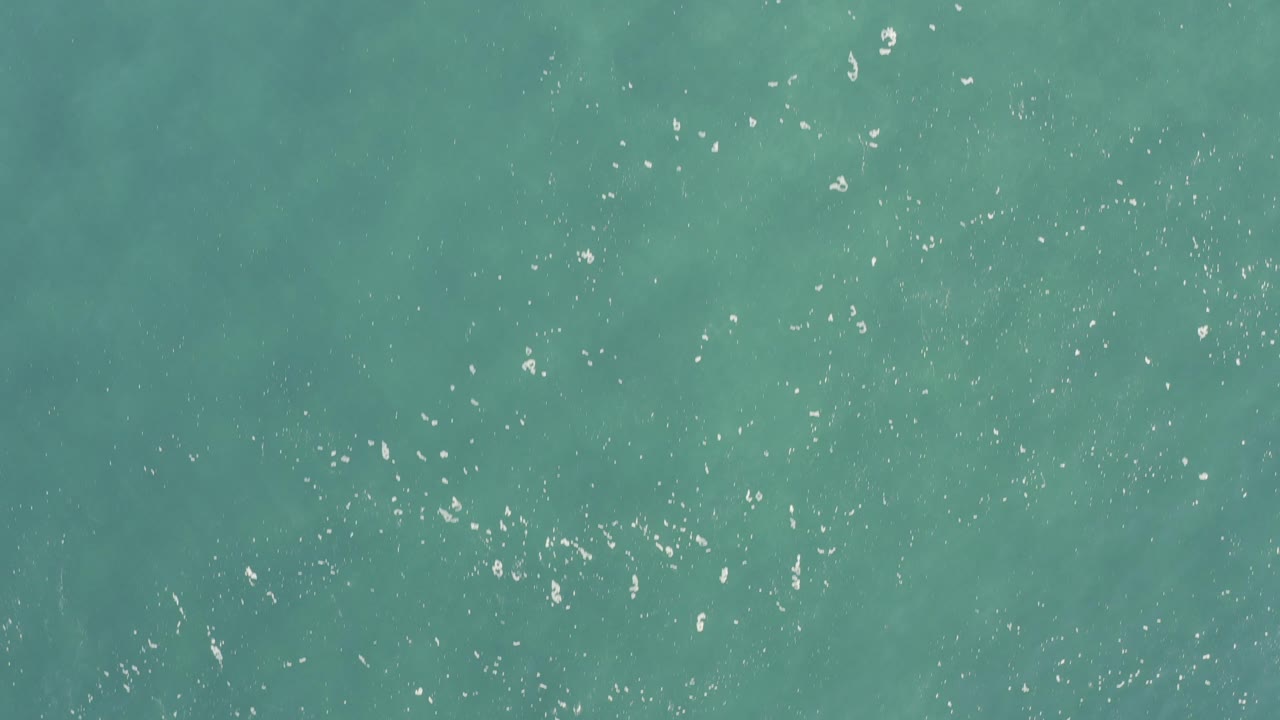 Overhead turquoise seawater in Baja California Sur, Mexico, with scattered white surface glints and no visible people.