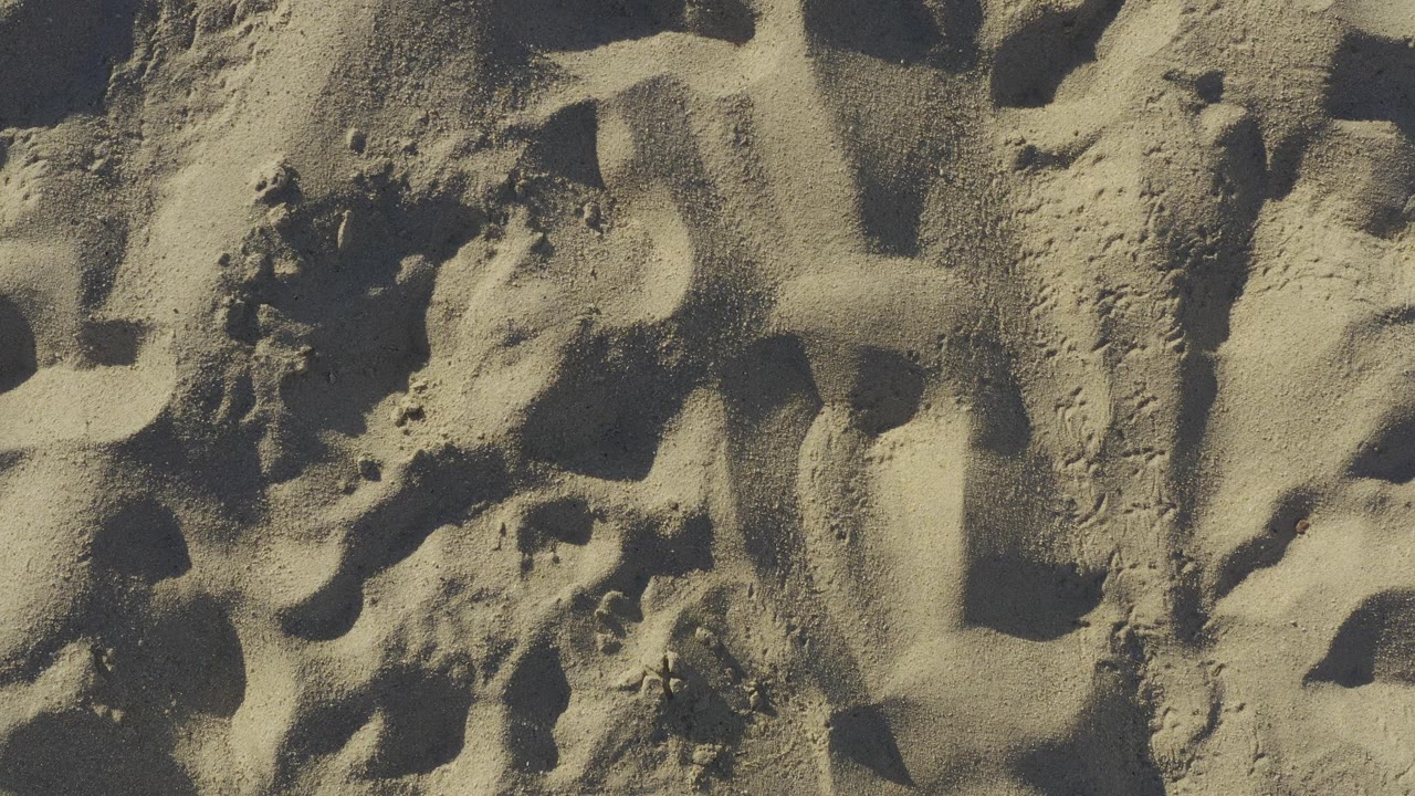 Close view of footprint-marked tan sand