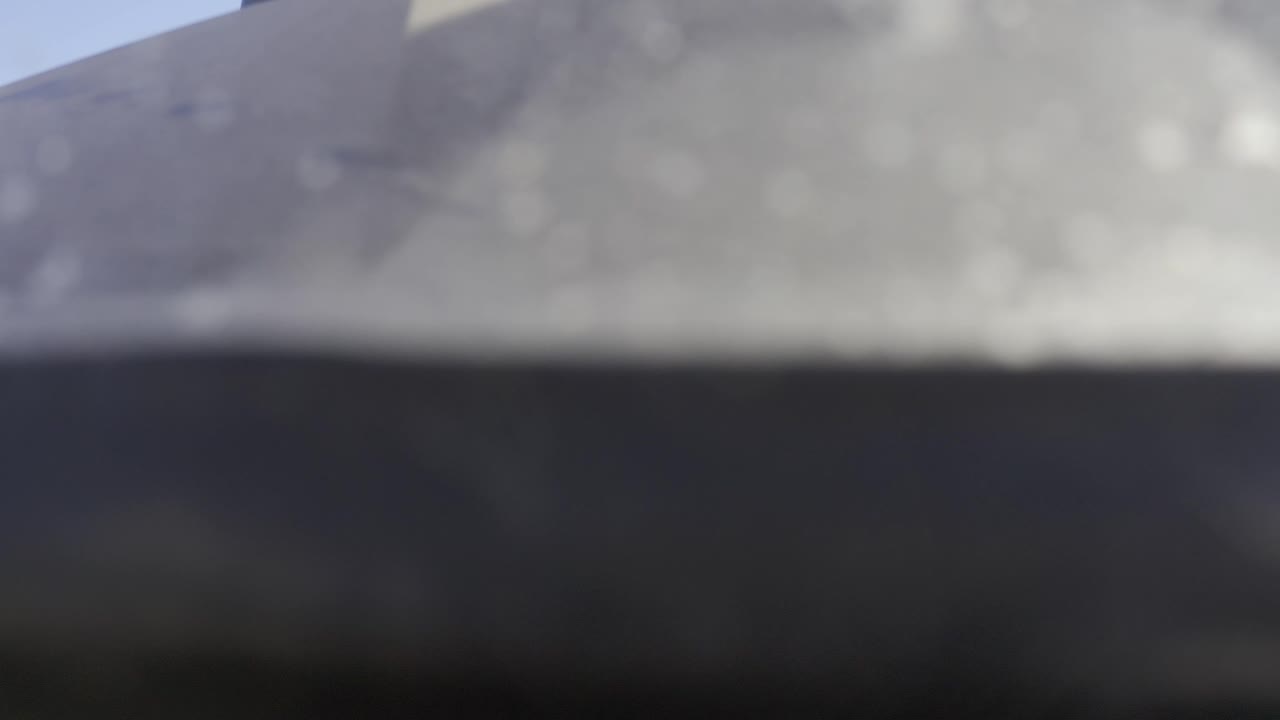 Pale blurred rock surface with a black band below it.