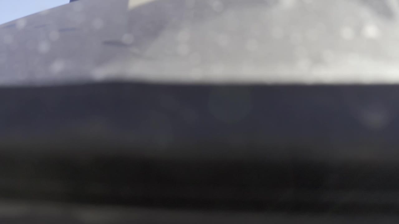 Out-of-focus pale surface above a dark horizontal strip.