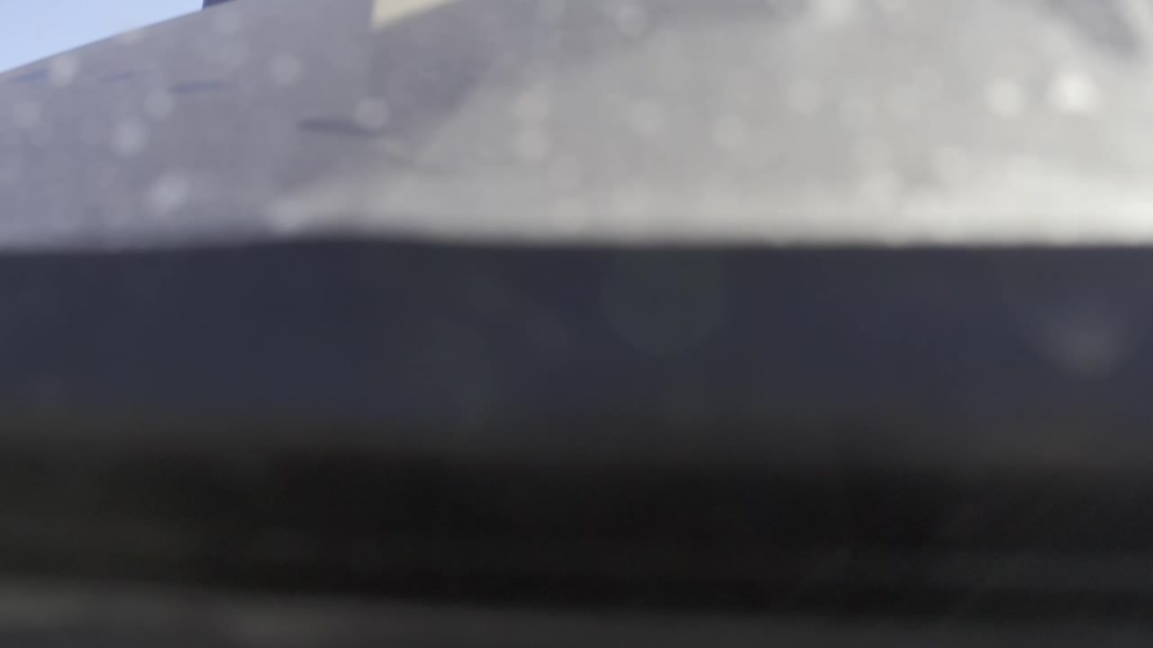 A soft, out-of-focus Baja California Sur view with gray high terrain across the upper frame and a dark forested strip through the lower frame, with no visible people.