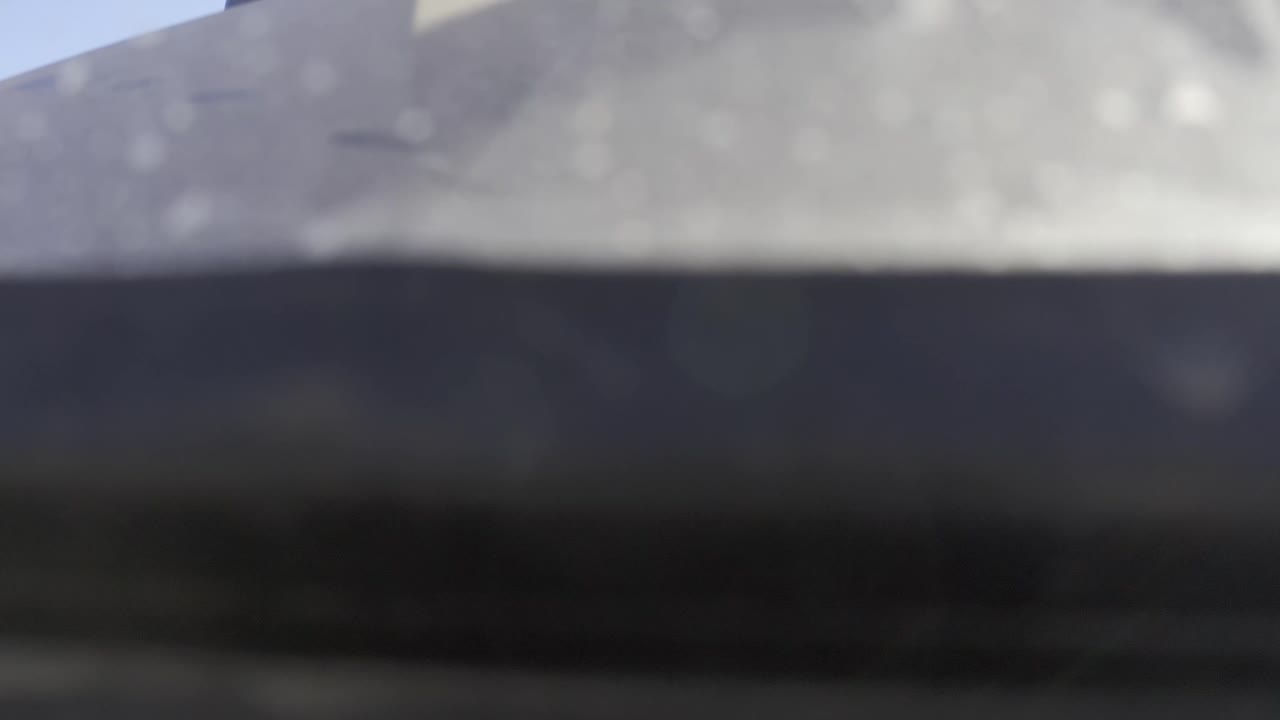 At 0:01, the Baja California Sur Mexico frame remains out of focus, with the dark lower band slightly shifted under a pale gray upper plane and no visible people.