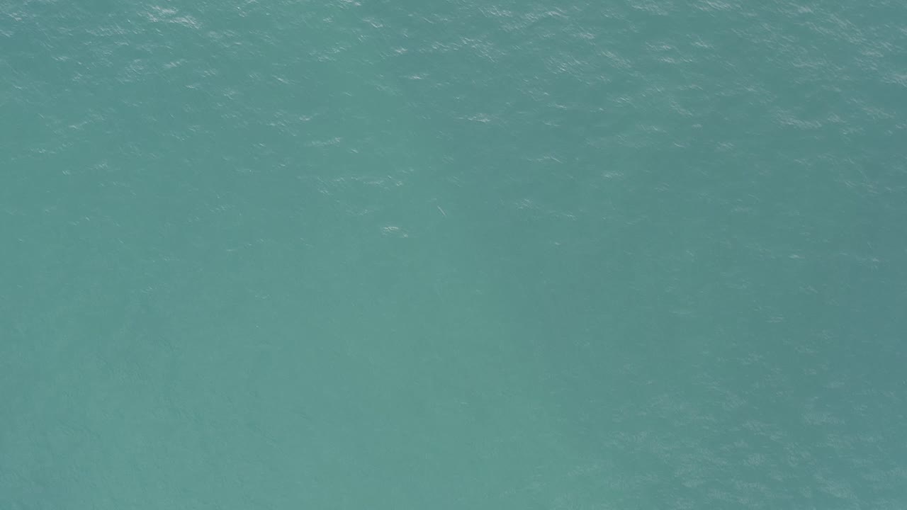 Calm teal water viewed from above in Baja California Sur, Mexico, with subtle tonal shifts below the surface and no visible people.