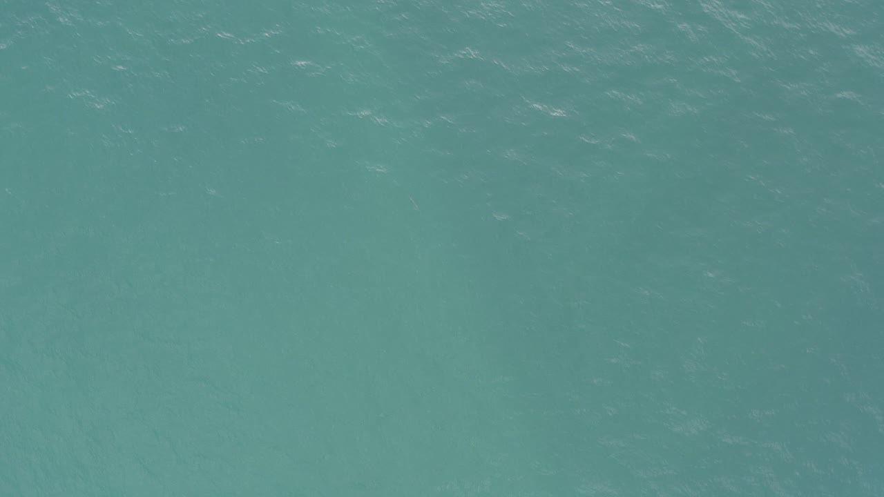 Close view of green-blue ocean surface in Baja California Sur, Mexico, with fine white ripple lines and no visible people.