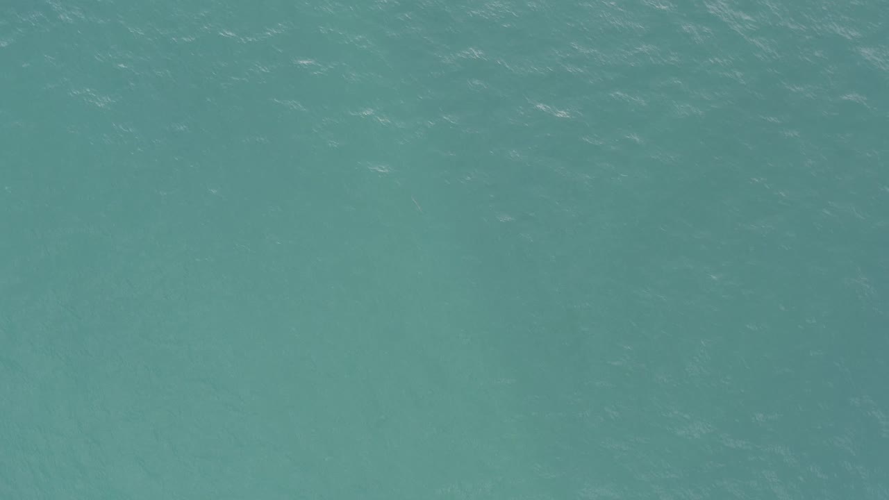 Turquoise ocean water in Baja California Sur, Mexico, fills the frame with scattered pale streaks on the surface and no visible people.