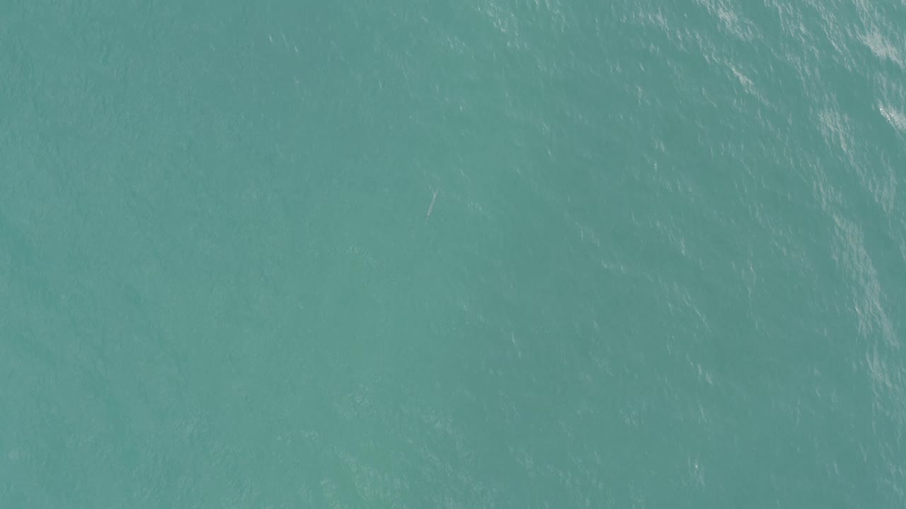 Clear turquoise water in Baja California Sur shows faint darker marks below the surface, soft ripple texture, and no visible people.