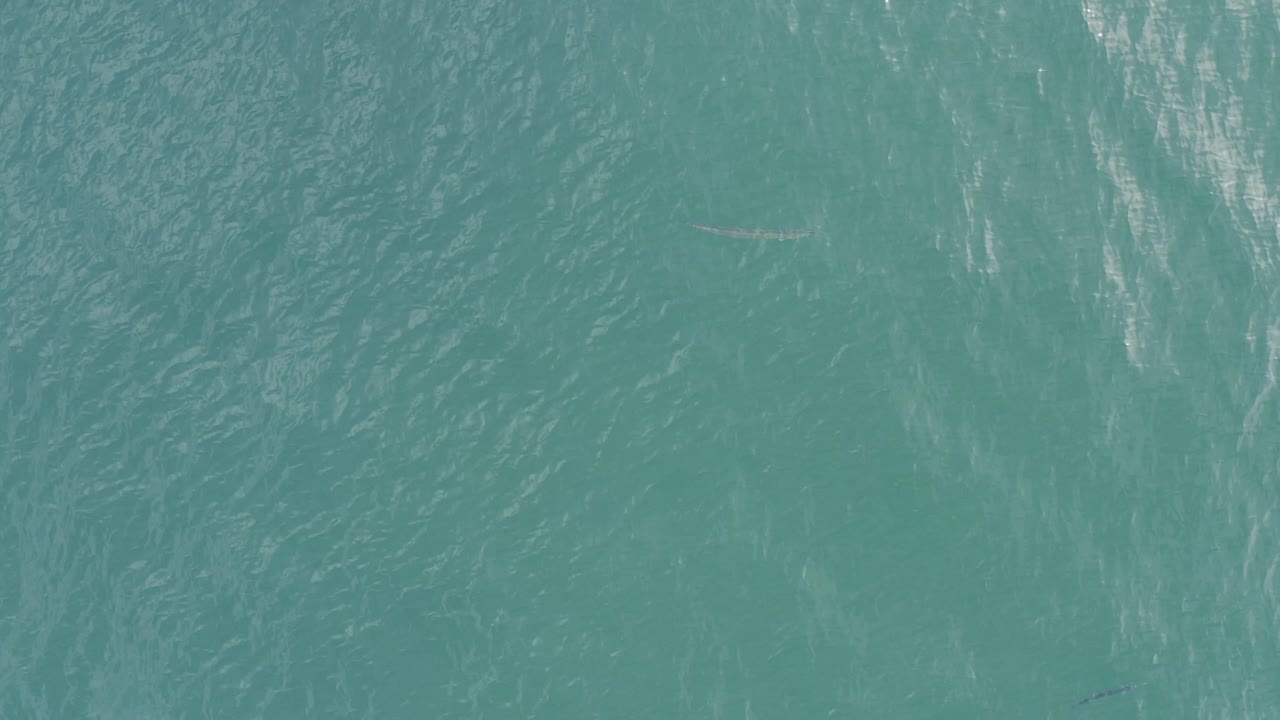 Aerial view of turquoise water in Baja California Sur, Mexico, with soft linear wave marks crossing the surface and no visible people.