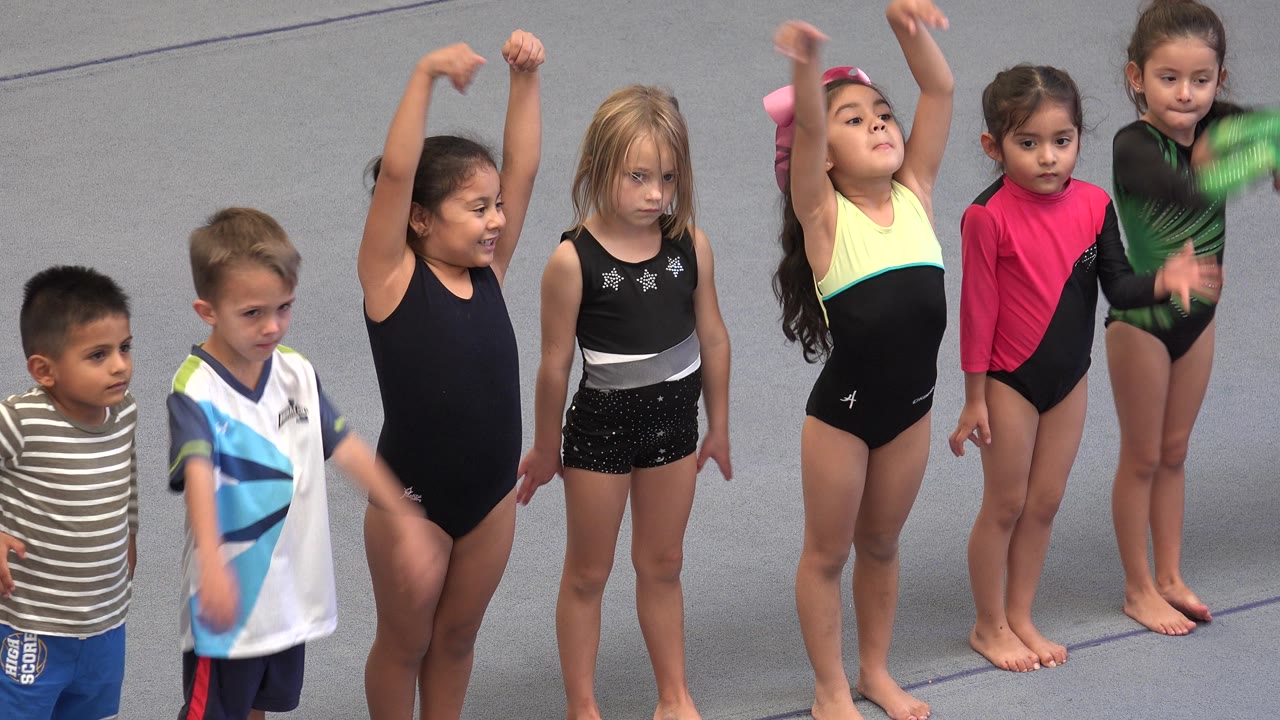 Children raise their arms during the exercise routine.