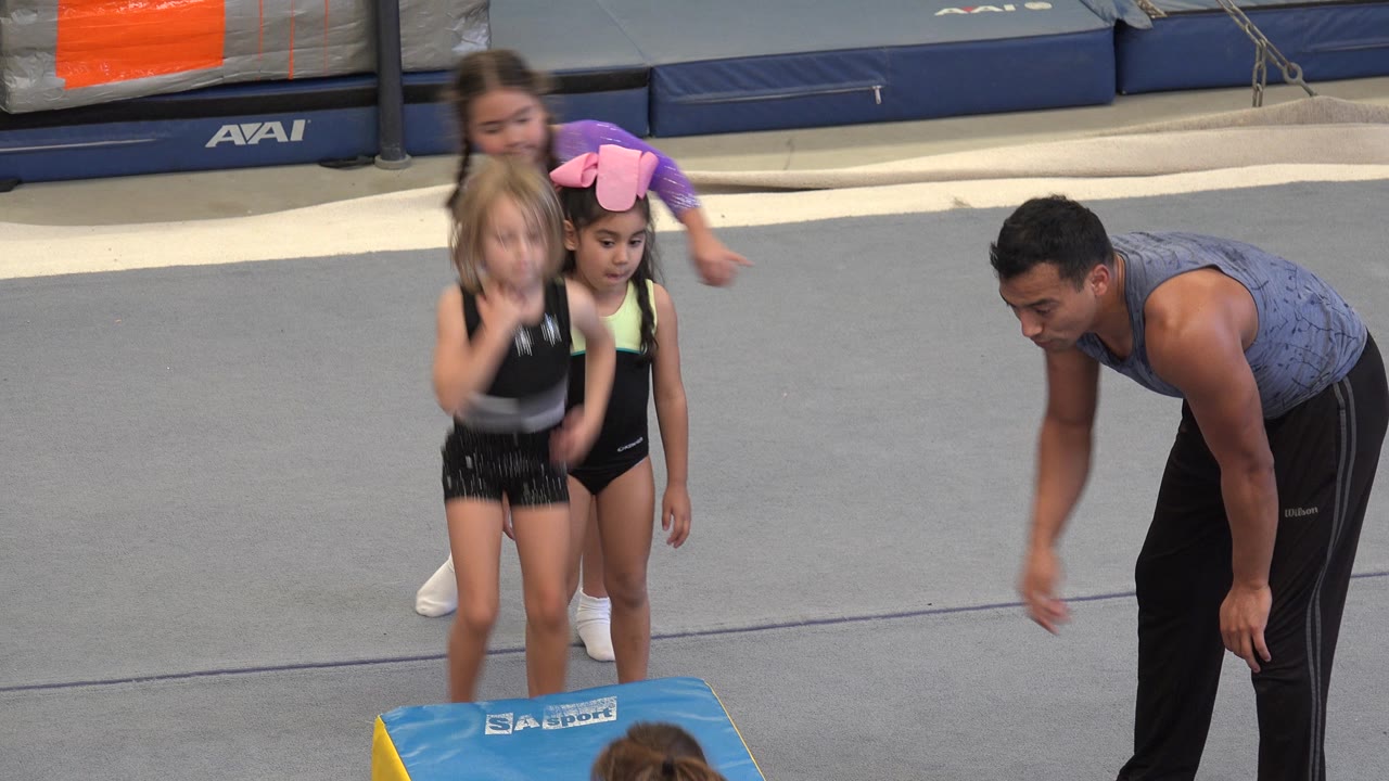 A girl moves quickly past the block while others wait.
