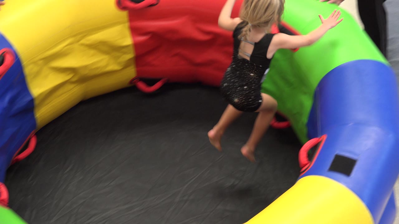 The child moves across the black center toward the green and blue edge of the inflatable play structure in Cabo San Lucas, Mexico.