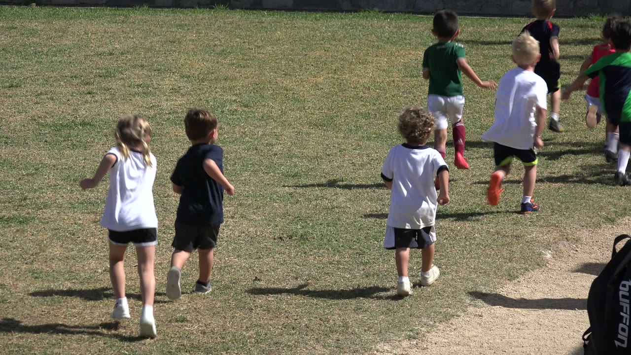 Children running away across a grassy field