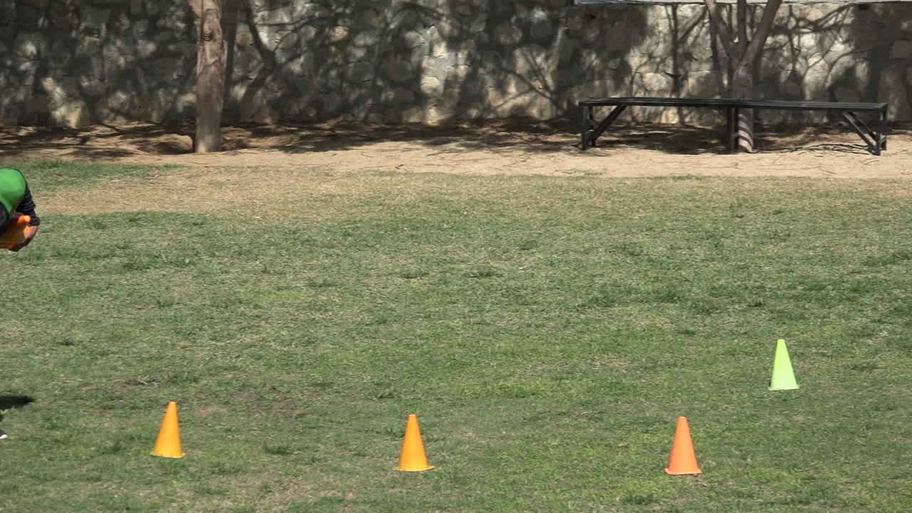 Person partly visible near the top of a grassy cone drill area.