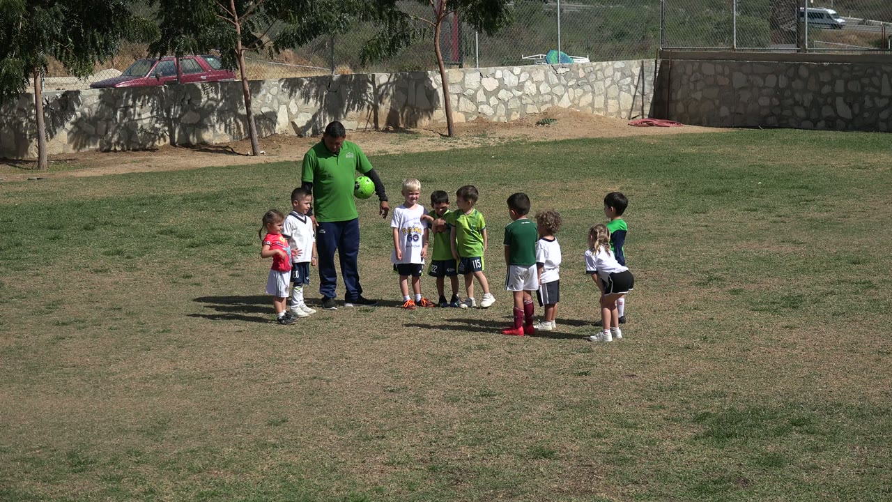 Small group of children and an adult on a field.