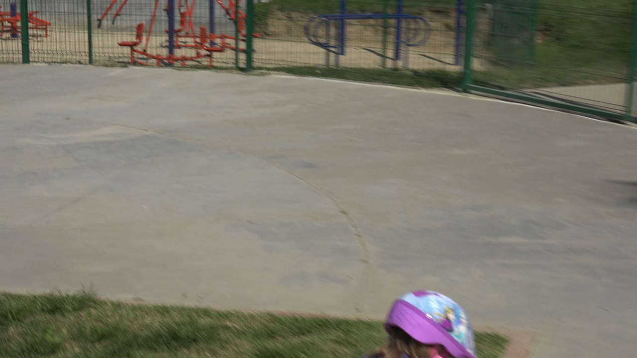 Playground pavement with a child partly entering frame at the bottom.