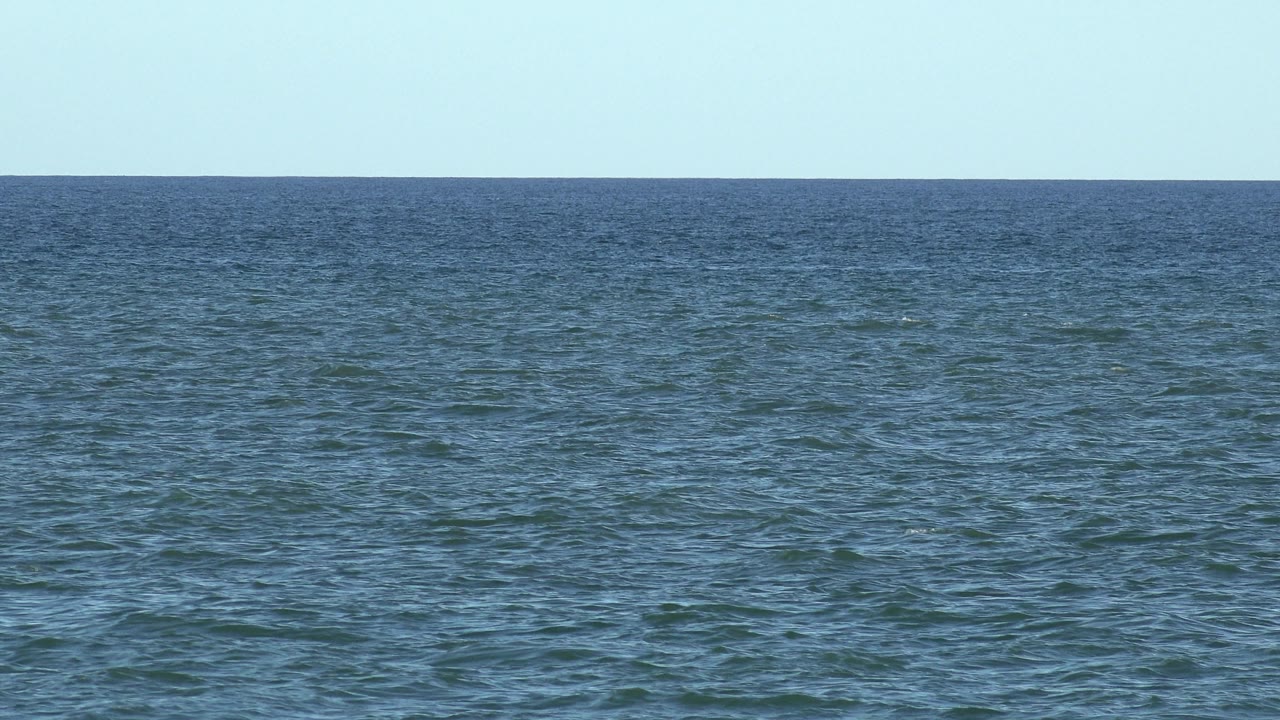 Blue-green water filling the frame below the horizon.