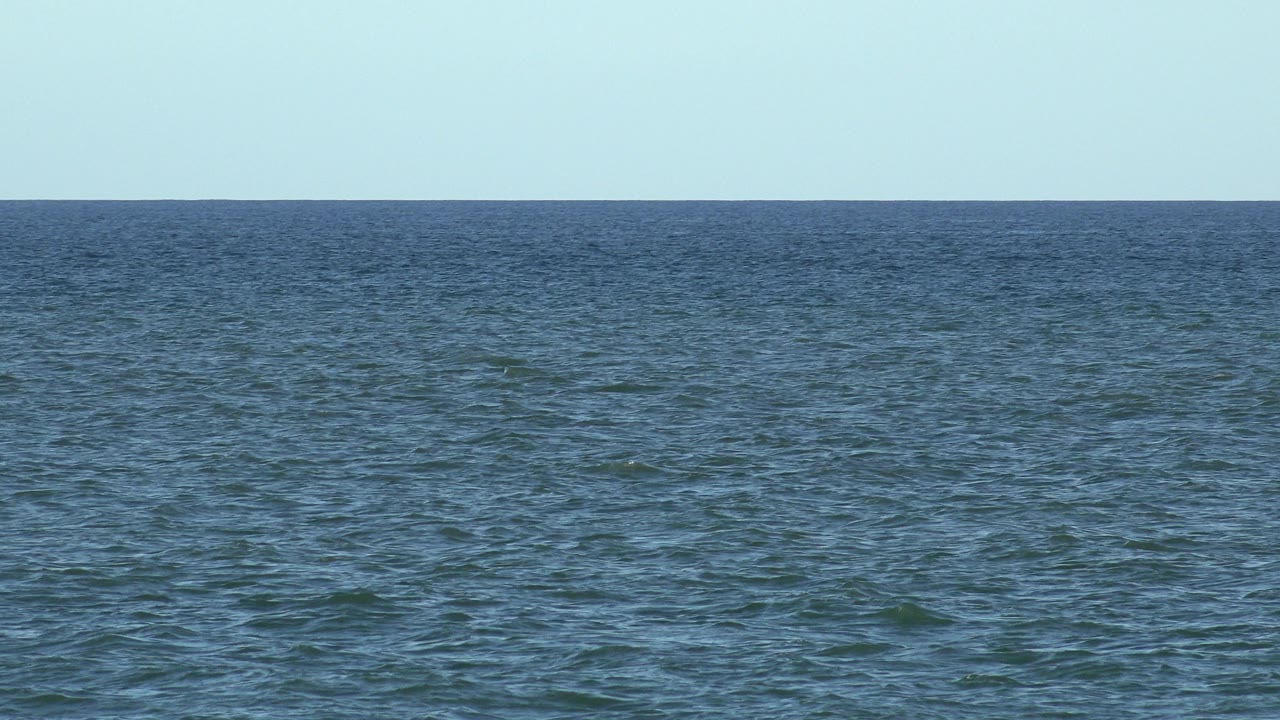 Los Cabos sea horizon one second in, showing textured water across the frame under a clear blue sky with no visible people.