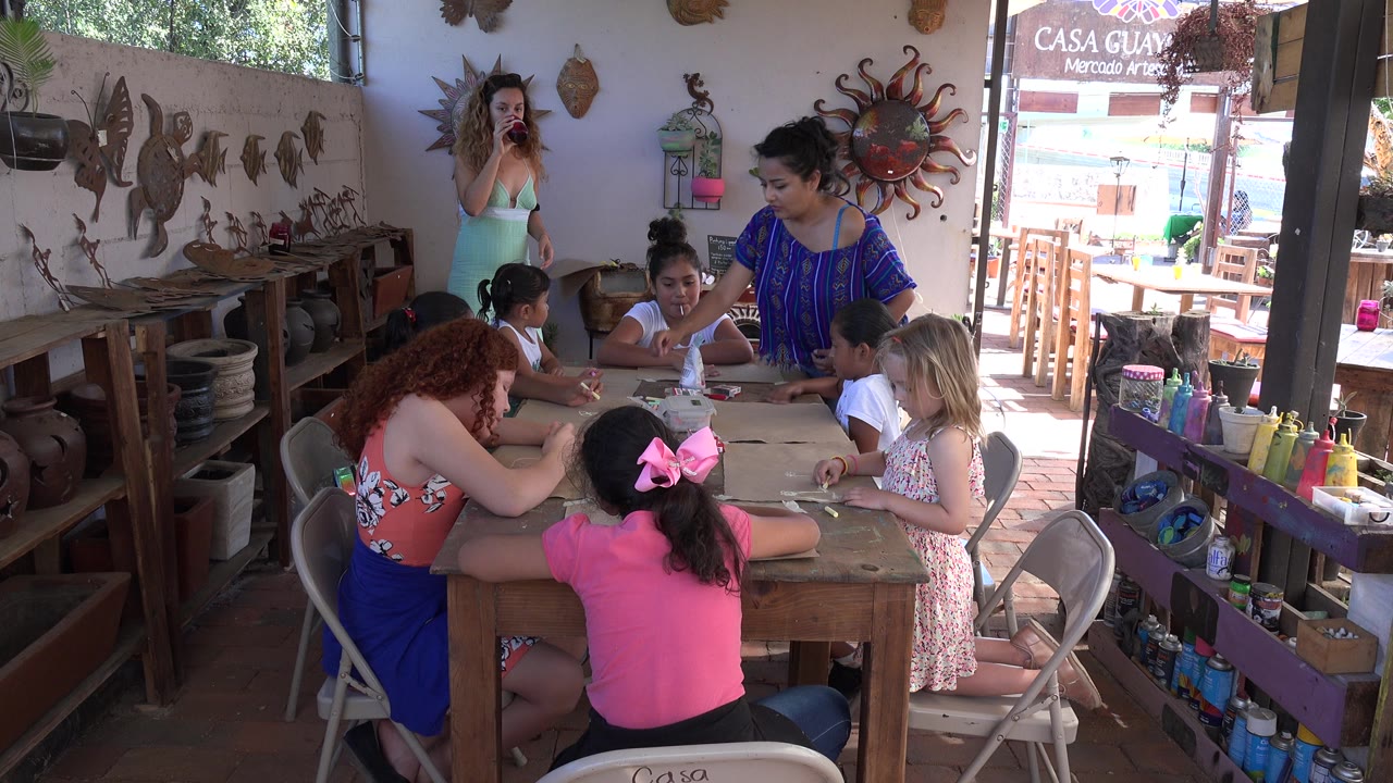 Children and adult women gathered around a craft table.